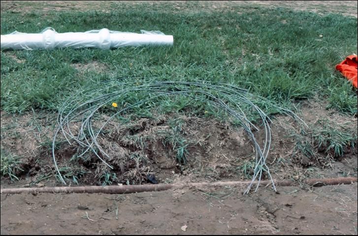 Figure 15. Nine-guage wire hoops to support polyethylene tunnels, with a roll of slitted cover in background.