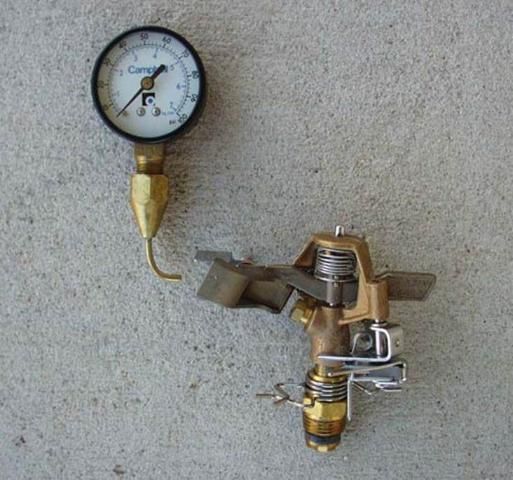 A pitot tube with pressure gauge is used to monitor pressure as water flows from the orifice.
