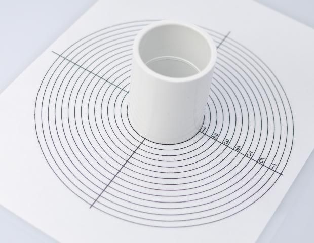 Figure 1. Hollow cylinder and laminated sheet of paper marked with diagram of concentric circles. (Note: a 1½