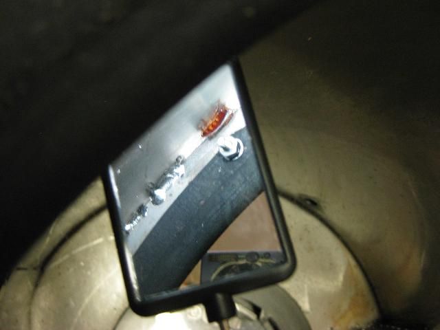 Figure 5. Use an inspection mirror and flashlight to help you see under and around areas that are difficult to reach. Inspection mirrors can be found in any hardware or auto mechanic store.