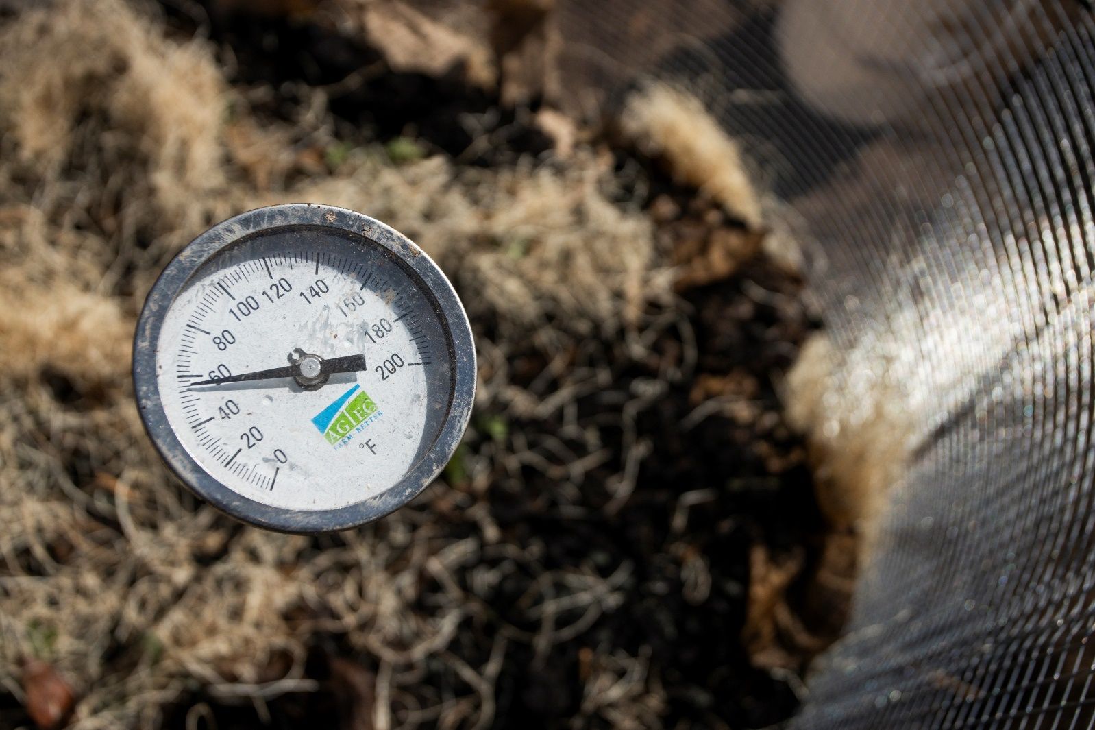 A compost bin with a compost thermometer. 