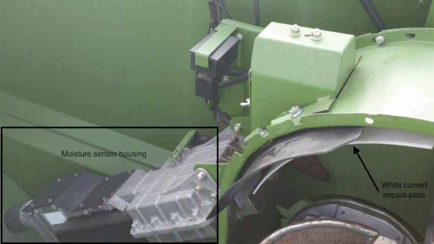 Figure 3. Curved impact-plate sensor (pointed by a black arrow) and moisture sensor housing (surrounded by a black rectangle) on the John Deere 9770 STS combine.