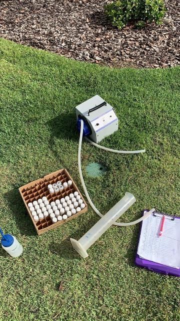 Equipment and supplies for leachate sample collection, including battery-powered peristaltic pump, graduated collection container, rinse bottle with deionized water for decontamination, sample collection bottles, and field sheet for recording leachate volumes.
