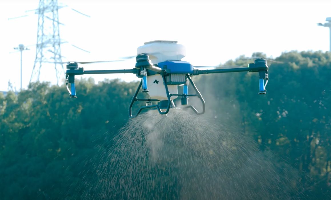 Spraying drone performing seeding with dry tank and spreader.