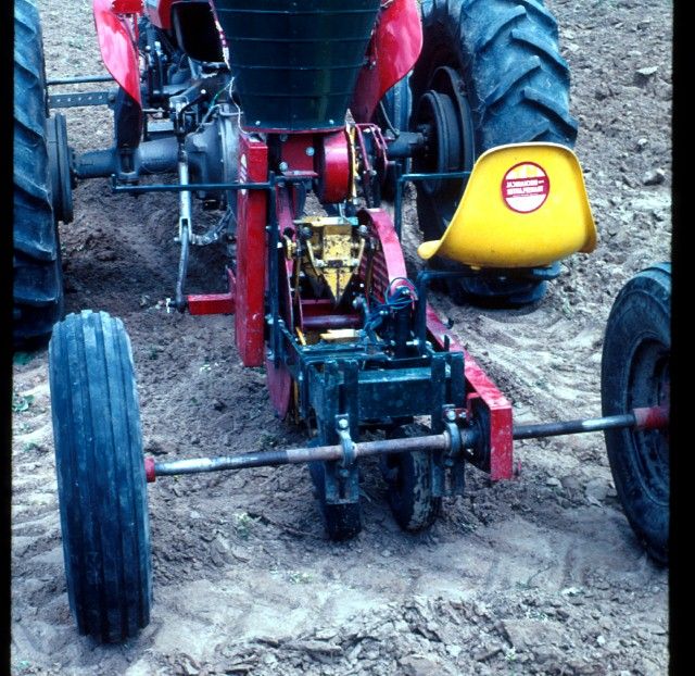Figure 7. Direct-seeding through plastic mulch can be accomplished with this plug-mix planter. The machine punches a hole in the mulch and places a small amount of soilless mixture and seed into the hole.