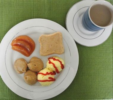 Figure 1. Huevos revueltos con salsa de tomate y tocineta; acompañado de tostada, duraznos y café con leche.