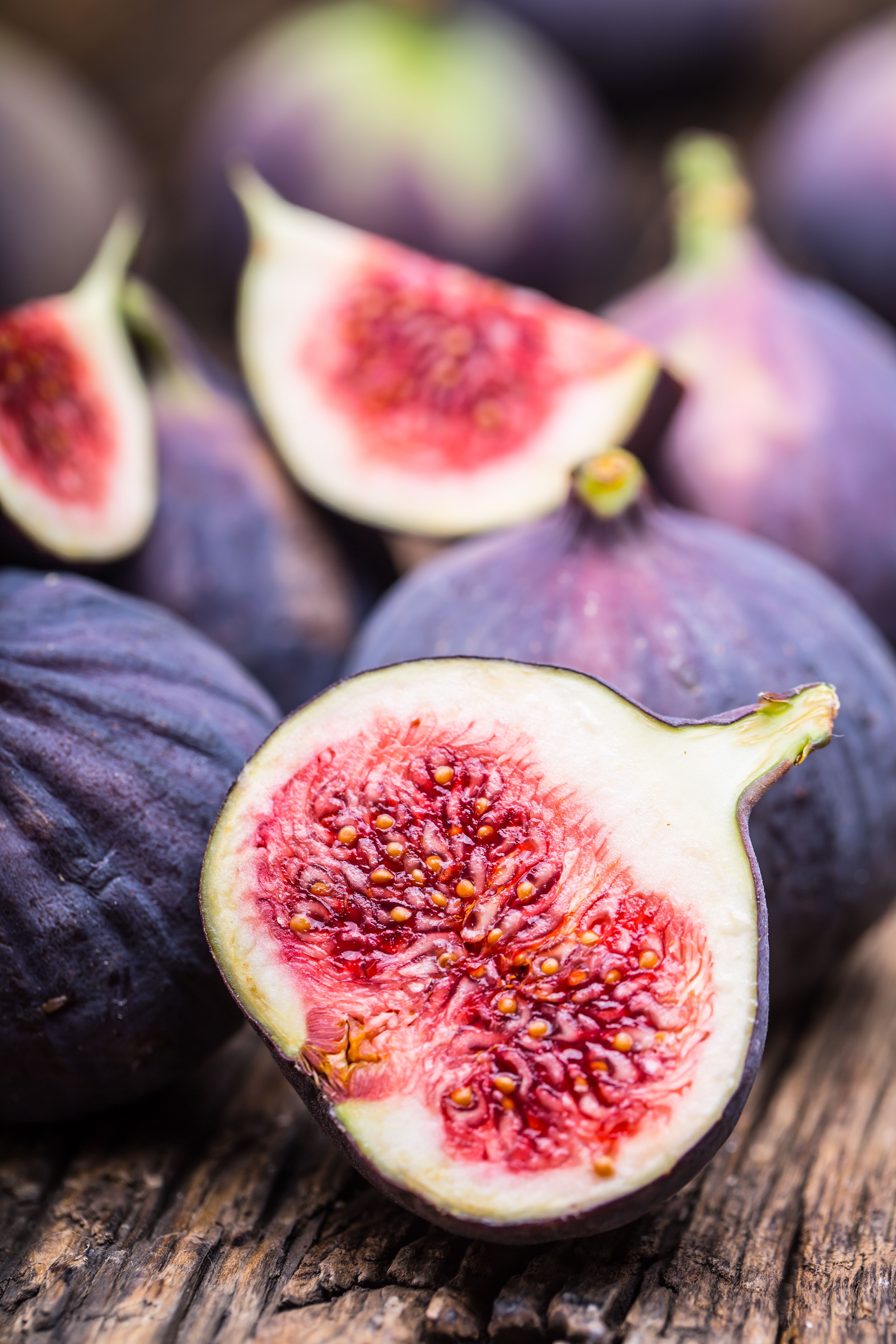 A sliced fig next to whole figs