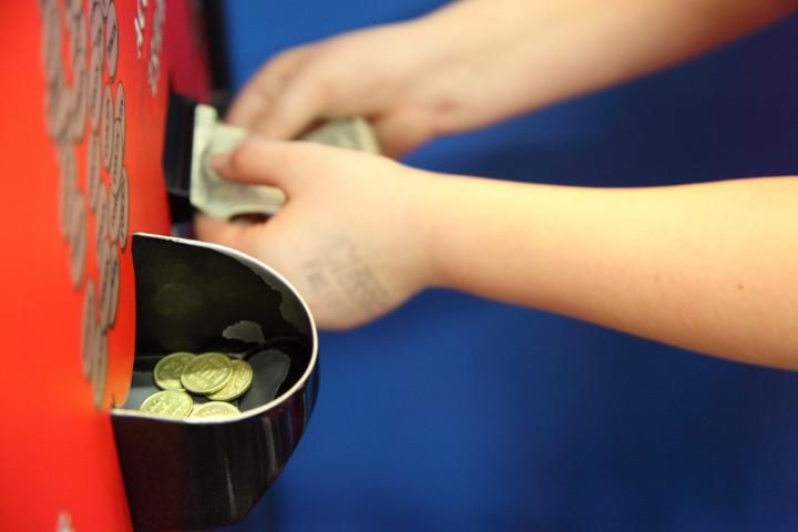Figure 1. Child putting money in arcade token change machine.