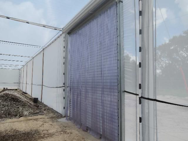 Steel roll-up door with a second plastic strip door, inside the UF/IFAS CREC CUPS.