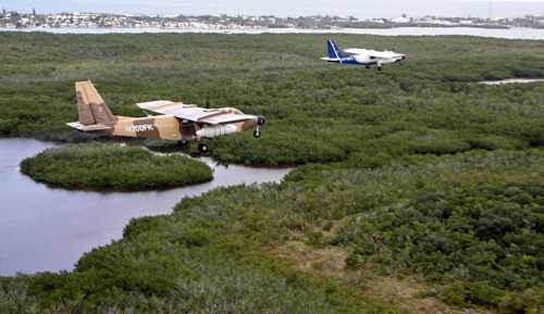Figure 16. Two planes applying an aerial insecticide treatment to a marsh.
