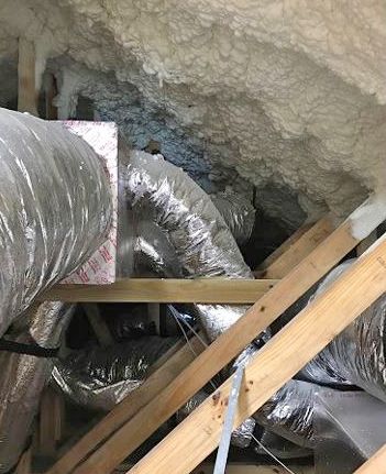 Figure 5. Spray foam insulation that obscures inspections and duct work that makes this space inaccessible for inspections.