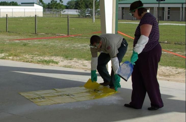 Cleaning a spill with absorbent.