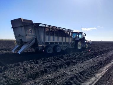 Rear planting elevator-style mechanical planter with chute-mounted nozzles.