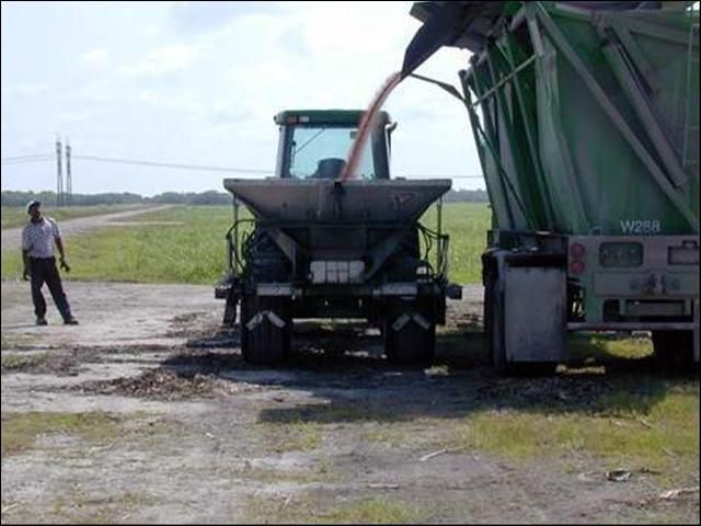 Sitio de cargamento de fertilizantes en terreno nivelado y lejos de zanjas abiertas y bancos de canales.