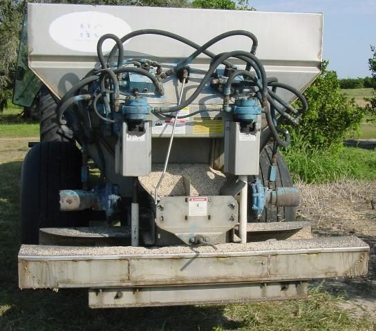 Figure 1. Conventional fertilizer spreader equipped with a split chain and rear deflector plates to apply dry, solid fertilizer beneath the citrus tree canopy.