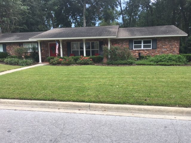 Another conventional yard in Gainesville, Florida. It is dominated by lawn and ornamental bushes. 
