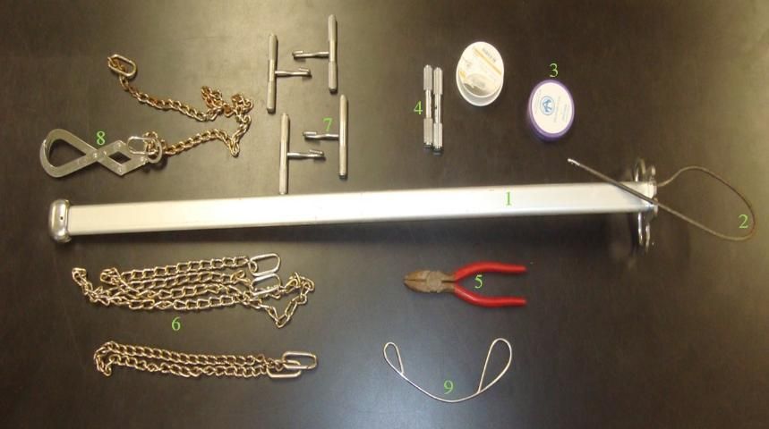 Figure 1. Obstetric tools required to perform a fetotomy in cattle: (1) fetotome, (2) obstetrical wire threader, (3) obstetrical wire, (4) obstetrical wire handles, (5) wire cutting pliers, (6) obstetric chains, (7) obstetrical handles, (8) Krey's hook with chain, and (9) obstetrical wire guide.