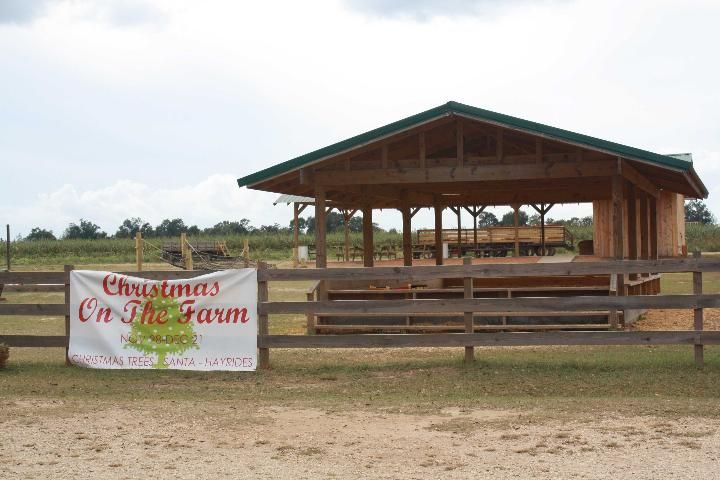 Figure 1. Nonresidential farm building. A wooden building with no walls sits at the right of the image. Across the front is a wooden rail fence with a white sign reading 